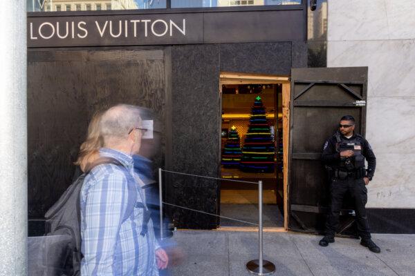 A security guard watches the entrance to a Louis Vuitton store near Union Square in San Francisco on Nov. 30, 2021. The store boarded up its windows as a security measure amid a spike in thefts. (Ethan Swope/Getty Images)