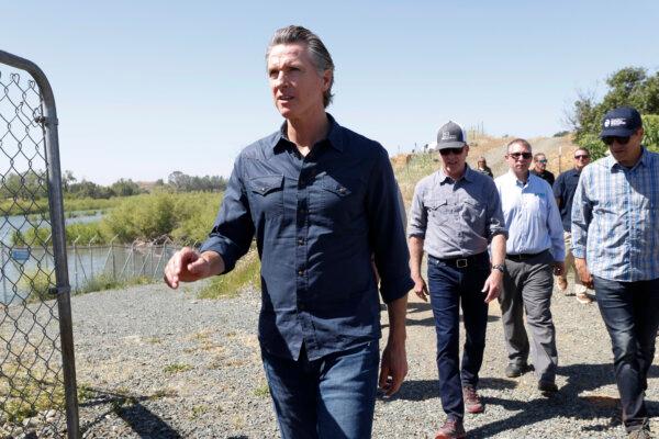 California Gov. Gavin Newsom (L), Wade Crowfoot, CNRA Secretary (R), and Chuck Bonham, CDFW Director (2-L) walk along the Lower Yuba River to the Daguerre Point Dam in Marysville, Calif., on May 16, 2023. (John G. Mabanglo-Pool/Getty Images)