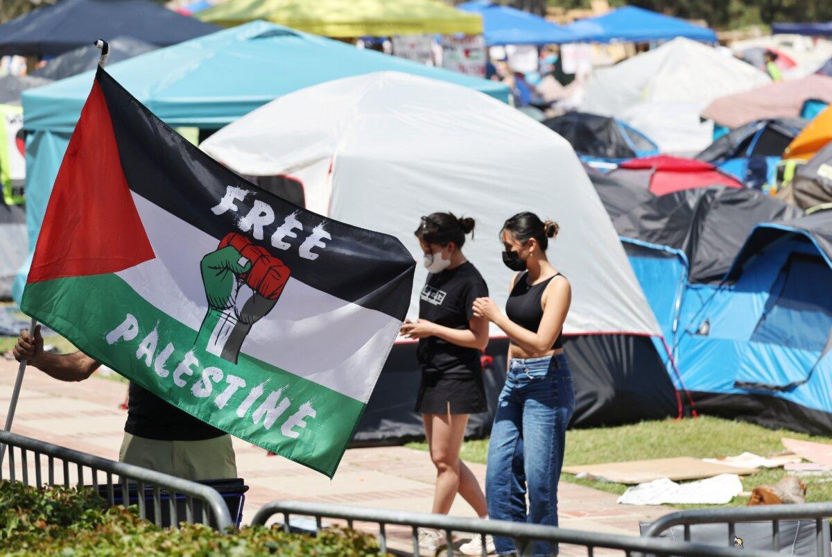 A protester carries a Palestinian flag at a pro-Palestinian encampment at the University of California, Los Angeles (UCLA) campus in Los Angeles on April 30, 2024. (Mario Tama/Getty Images)