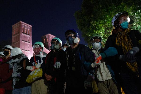 Pro-Palestine protestors link arms across from members of law enforcement in an encampment at UCLA in Los Angeles on May 2, 2024. (Eric Thayer/Getty Images)