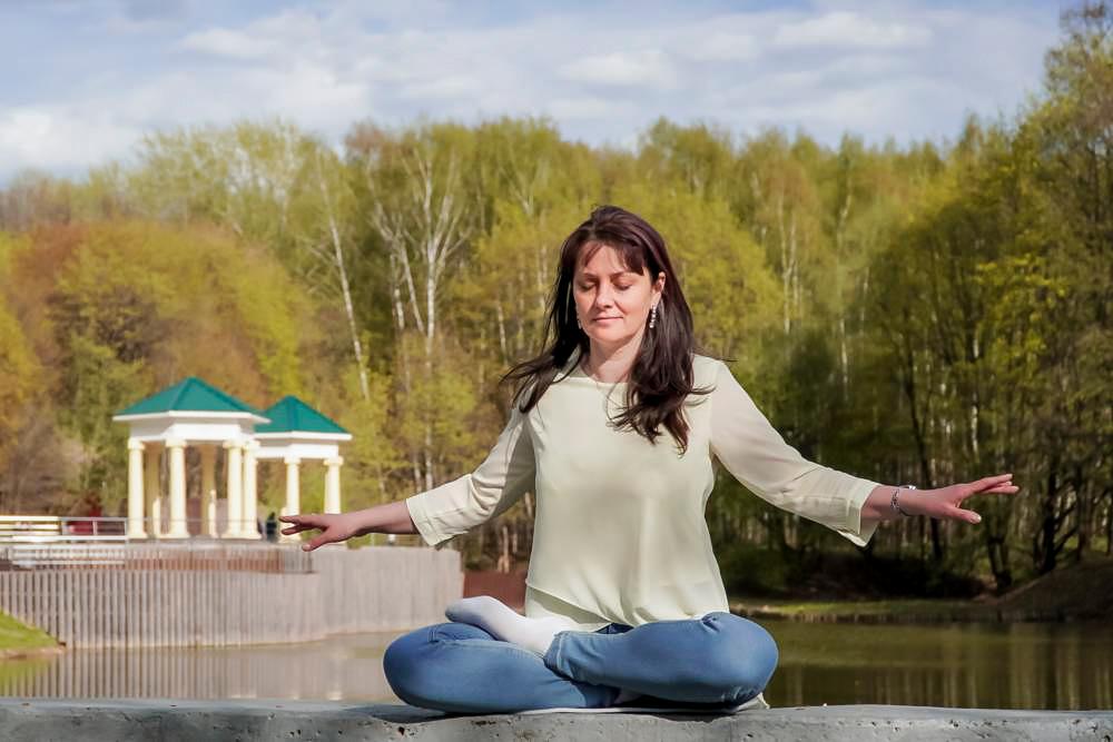 Natalya Minenkova does Falun Gong meditation in Dendropark in Moscow, Russia, on July 5, 2022. (The Epoch Times)