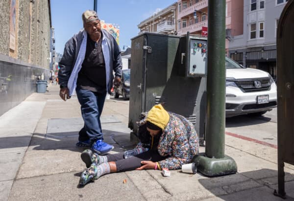 JJ Smith checks on the well-being of homeless drug addicts in the Tenderloin District of San Francisco on May 16, 2024. (John Fredricks/The Epoch Times)