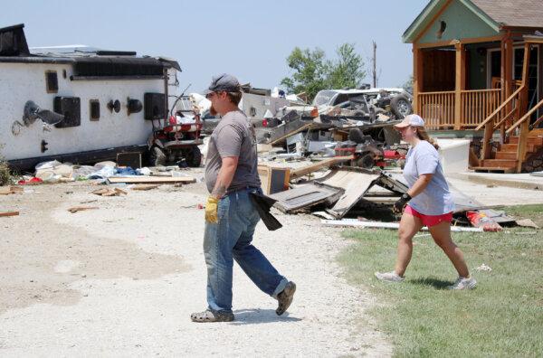 Volunteers walk through the destroyed Lake Ray Roberts Marina RV park on May 26, 2024. The park, just outside Valley View, Texas, was destroyed by a tornado the night before. (Michael Clements/The Epoch Times)