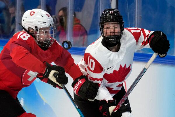 Sarah Fillier of Team Canada (R) battles for the puck against Switzerland's Stefanie Wetli during a women's semifinal at the 2022 Winter Olympics in Beijing on Feb. 14, 2022. (Petr David Josek/AP Photo)