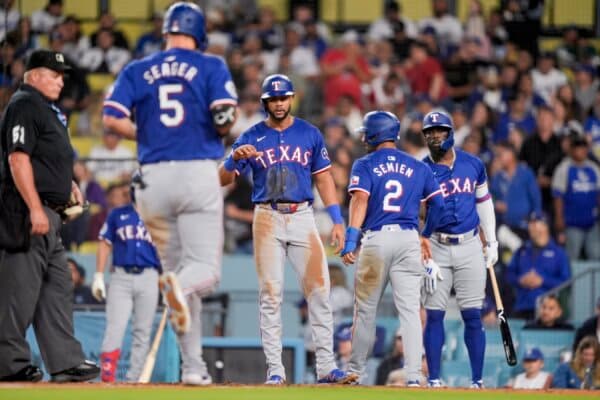 Texas Rangers designated hitter Corey Seager (5) scores on a three-run home run against the Los Angeles Dodgers as Leody Taveras, Marcus Semien and Adolis Garcia (L to R) wait to congratulate him during the fifth inning of a baseball game in Los Angeles on June 12, 2024. (Ryan Sun/AP Photo)