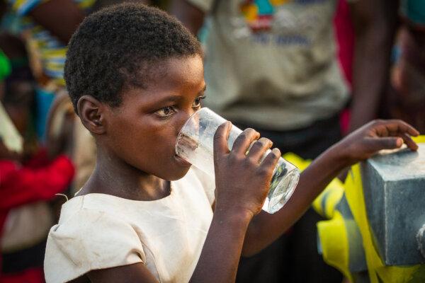 A girl drinks from a well built by Water Wells for Africa in Southern Malawi on June 20, 2017. (John Fredricks/The Epoch Times)