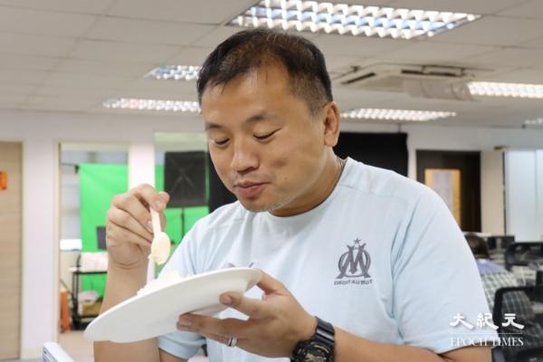 Ronson Chan eats a piece of cake in his office. (Terence Tang/The Epoch Times)