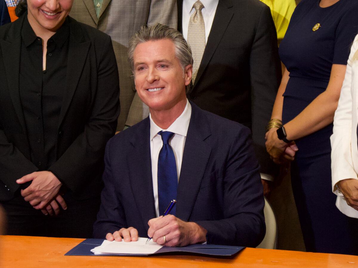 Gov. Gavin Newsom signs a package of 10 retail theft bills at a Home Depot in San Jose, Calif., on Aug. 16, 2024. (Travis Gillmore/The Epoch Times)
