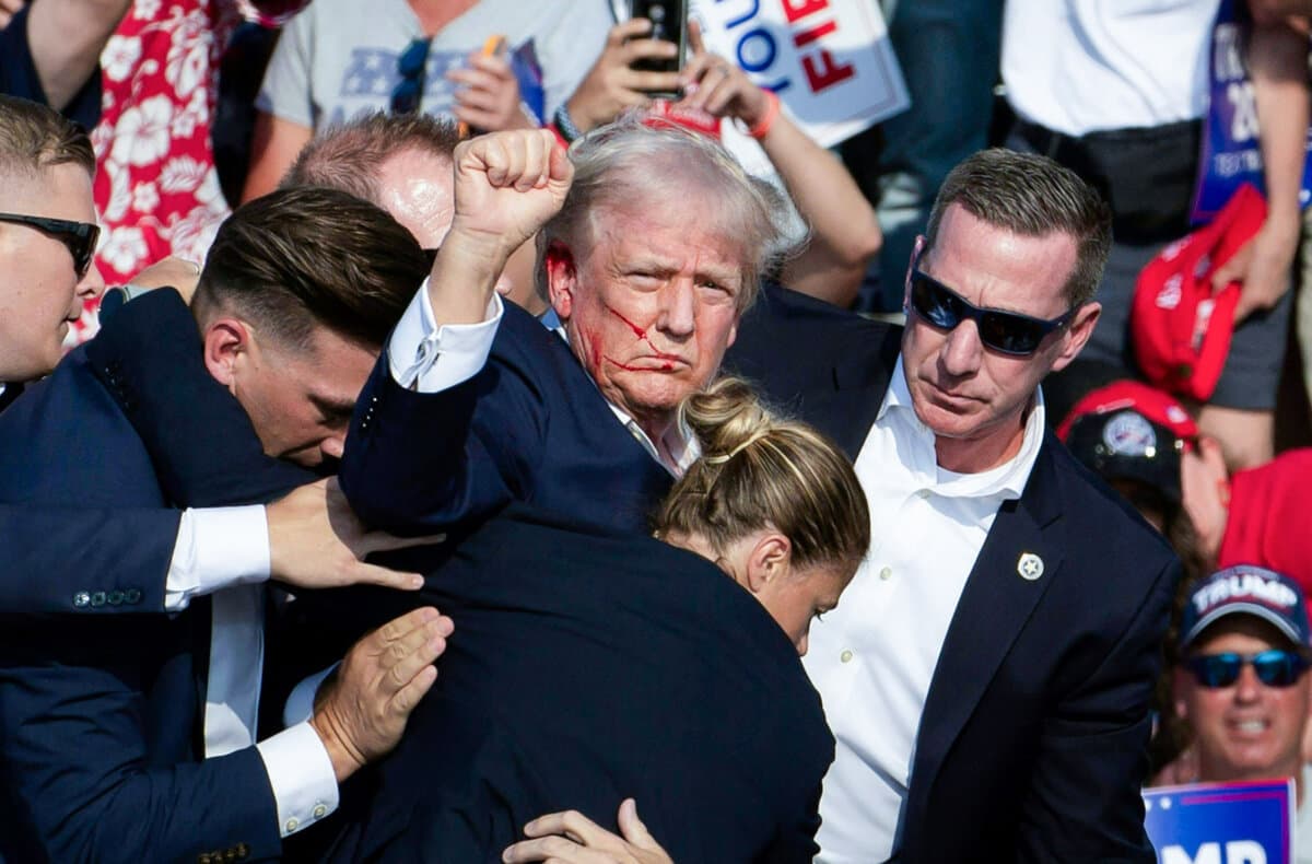 Then former President Donald Trump, with blood on his face, is surrounded by Secret Service agents after being shot by would-be assassin Thomas Crooks at Butler Farm Show Inc. in Butler, Pa., on July 13, 2024. (Rebecca Droke/AFP via Getty Images)