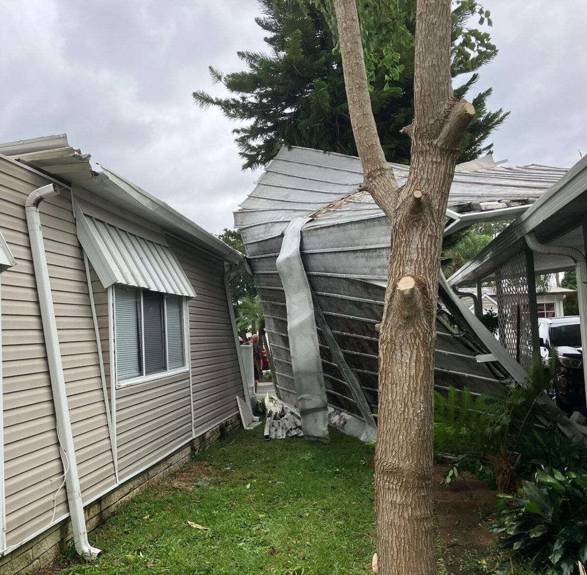 Sean Ryder looks through the mangled remains of the roof of his home in the Highland Village Mobile Home Park near Lakeland, Fla., on Oct. 10, 2024. (John Haughey/The Epoch Times)