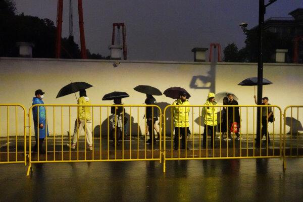 Police officers keep watch near barricades set up along Julu Road, where people in Halloween costumes gathered the year before, in Shanghai on Oct. 26, 2024. (Nicoco Chan/Reuters)