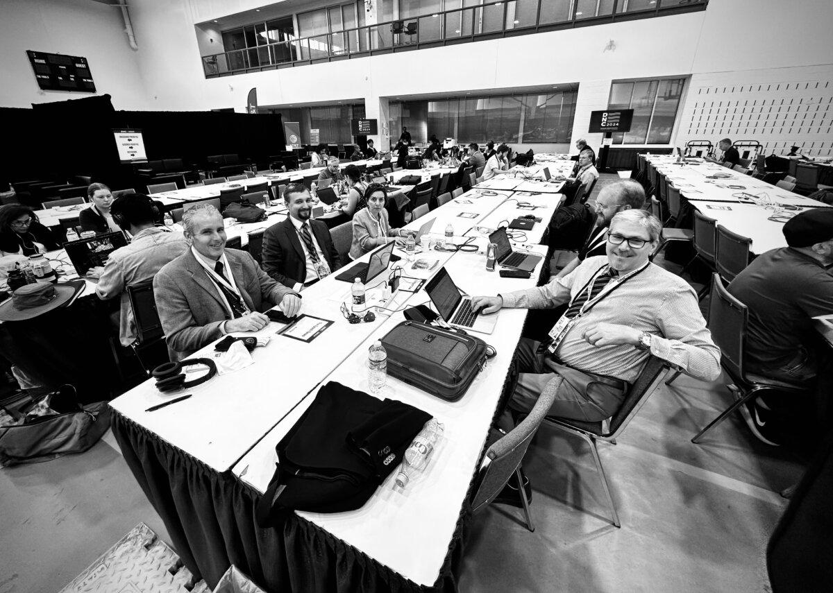 Epoch Times reporter Lawrence Wilson (R) works alongside colleagues and other journalists at the Democratic National Convention in Chicago on Aug. 22, 2024. (John Fredricks/The Epoch Times)