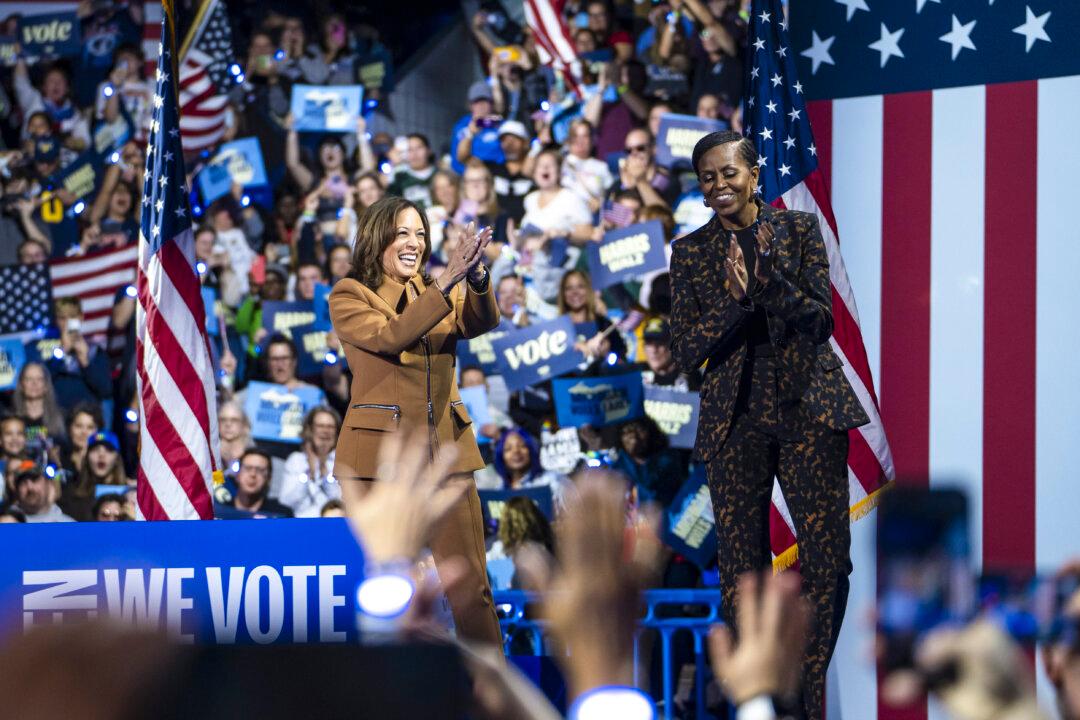 Democratic Presidential candidate Vice President Kamala Harris and former First Lady Michelle Obama greet on the stage during an event at Wings Event Center in Kalamazoo, Mich., on Oct. 26, 2024. (Madalina Vasiliu/The Epoch Times)
