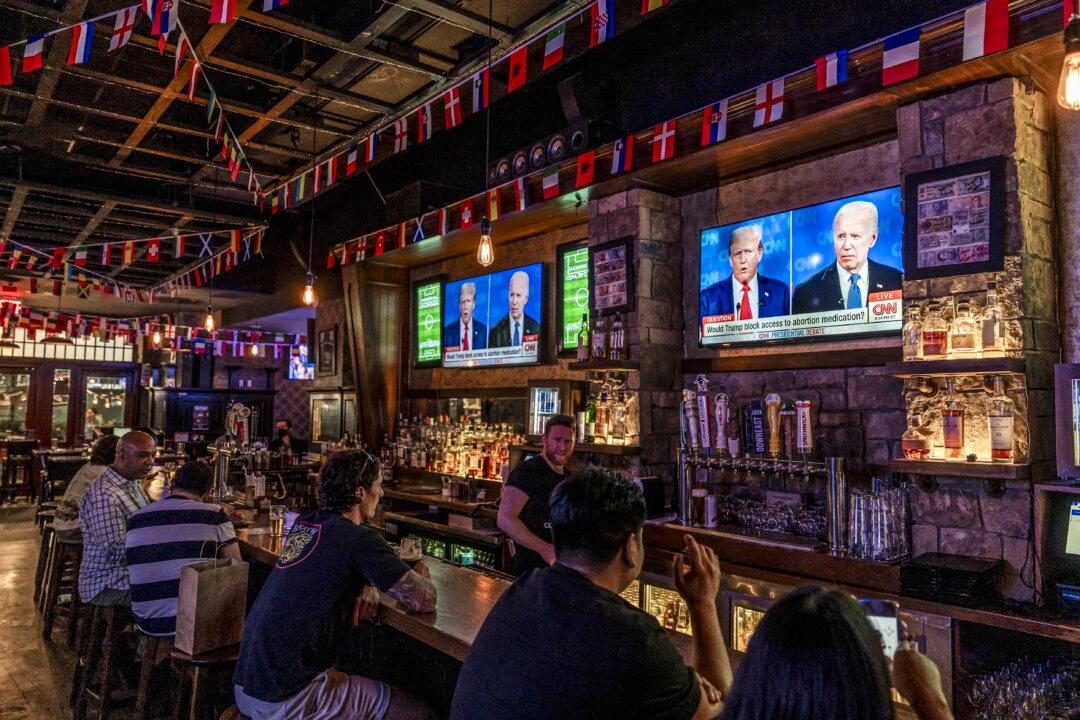 People watch the presidential debate between President Joe Biden and former President Donald Trump, at a bar in New York City on June 27, 2024. (Samira Bouaou/The Epoch Times)