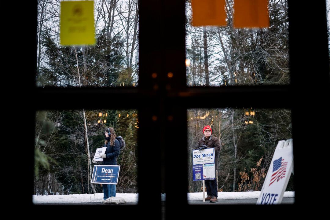 Mae Hougo (L), a volunteer for Rep. Dean Phillips (D-Minn.), and Chuck Willing, a volunteer with the President Joe Biden write-in campaign, stand outside the polling place at The Barn at Bull Meadow during the New Hampshire presidential primary in Concord, N.H., on Jan. 23, 2024. (Chip Somodevilla/Getty Images)