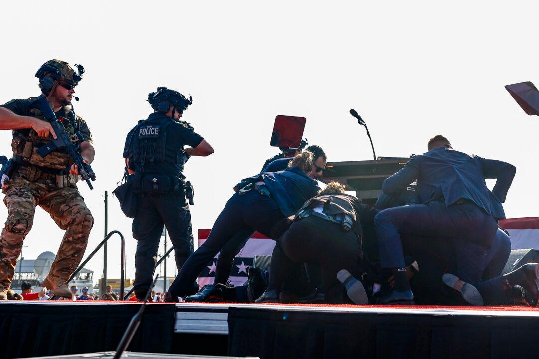 Republican presidential candidate former President Donald Trump is covered by U.S. Secret Service agents after a shooter opened fire during a rally in Butler, Pa., on July 13, 2024. The attempted assassination on former President Donald Trump injured his ear, killed one audience member and injured another in the shooting. (Anna Moneymaker/Getty Images)