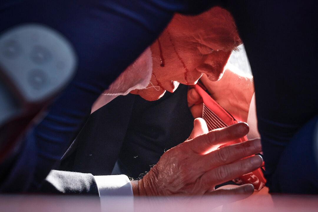 Republican presidential candidate former President Donald Trump is covered by U.S. Secret Service agents after an attempted assassination during a rally in Butler, Pa., on July 13, 2024. (Anna Moneymaker/Getty Images)