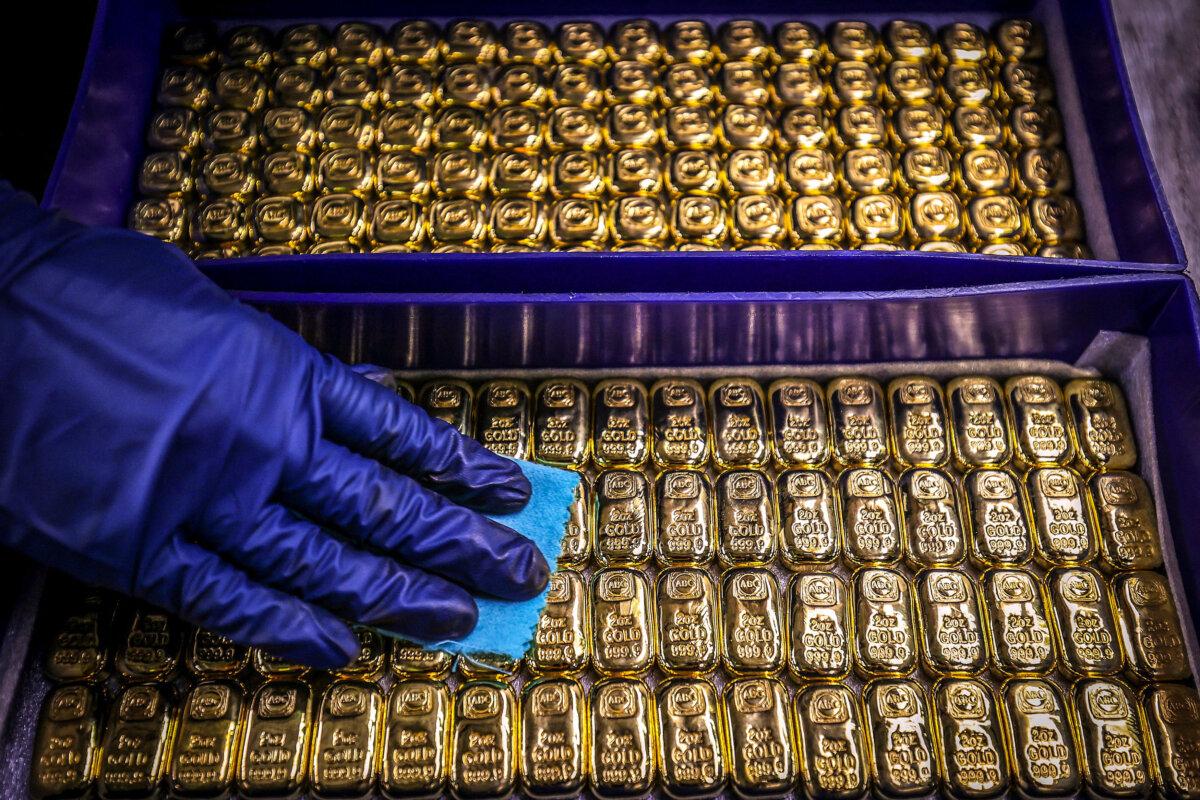 A worker polishes gold bullion bars at the ABC Refinery in Sydney on Aug. 5, 2020. (David Gray/AFP via Getty Images)