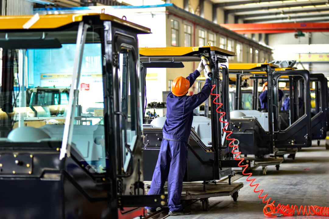 Workers build cabs for excavators at a factory in Qingzhou, Shandong Province, China, on Oct. 31, 2024. (STR/AFP via Getty Images)