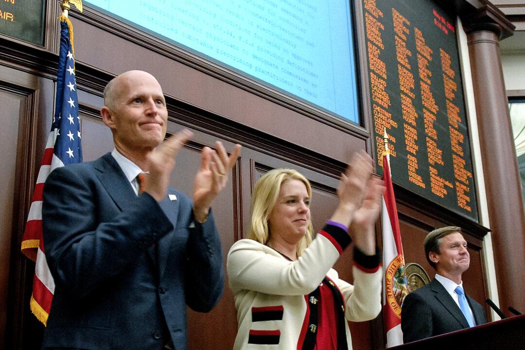 (L–R) Florida Gov. Rick Scott, Attorney General Pam Bondi, and House Speaker Dean Cannon celebrate unanimous approval of legislation at the Florida State Capitol in Tallahassee on May 6, 2011. (Florida House of Representatives/Public Domain)