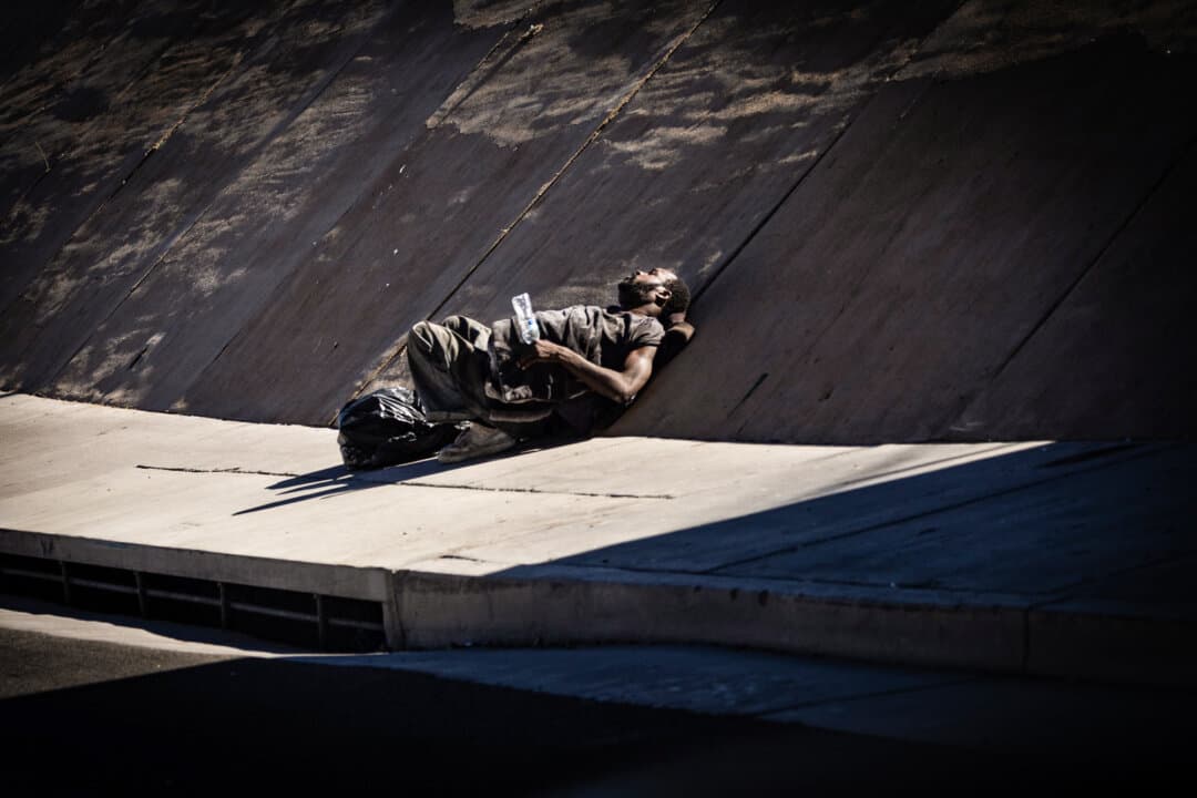A homeless man rests under a bridge in Las Vegas on Nov. 14, 2024. (John Fredricks/The Epoch Times)