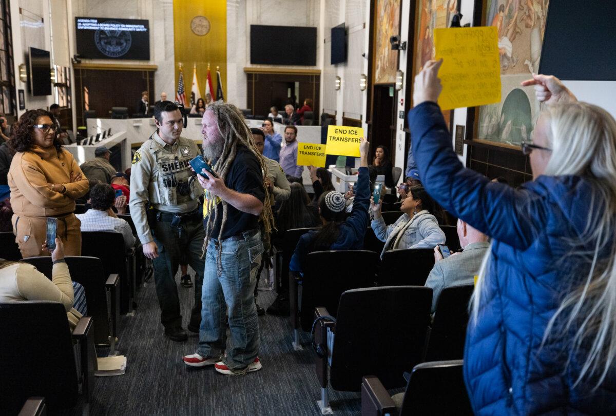 Matt Baker gets escorted out of a San Diego Board of Supervisors meeting in San Diego, Calif., on Dec. 10, 2024. (John Fredricks/The Epoch Times)