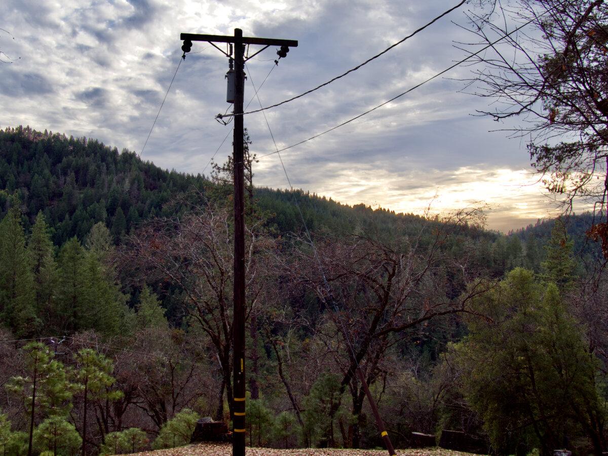 PG&E transmission lines cross through mountain terrain in Mendocino County in Northern California on Dec. 19, 2024. (Travis Gillmore/The Epoch Times)