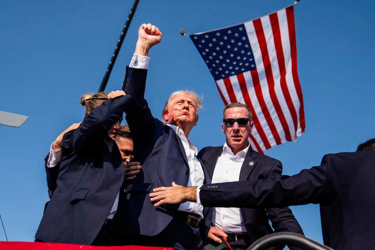 Republican presidential candidate former President Donald Trump raises his fist shortly after the assassination attempt at a campaign rally, in Butler, Pa., on July 13, 2024. The shooter was killed by the Secret Service. One attendee died in the shooting. (Evan Vucci/AP Photo)