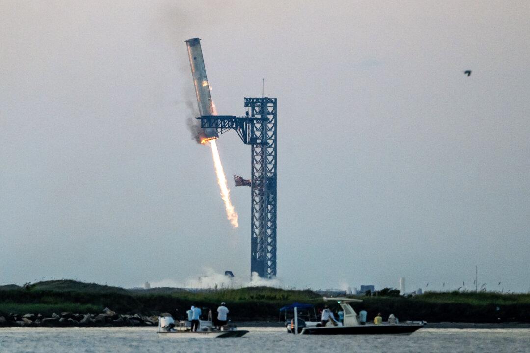 Starship's Super Heavy Booster is grappled at the launch pad in Starbase near Boca Chica, Texas, on Oct.13, 2024. SpaceX successfully “caught” the first-stage booster of its Starship megarocket as it returned to the launch pad after a test flight, a world first in the company's quest for rapid reusability. (Sergio Flores/AFP via Getty Images)