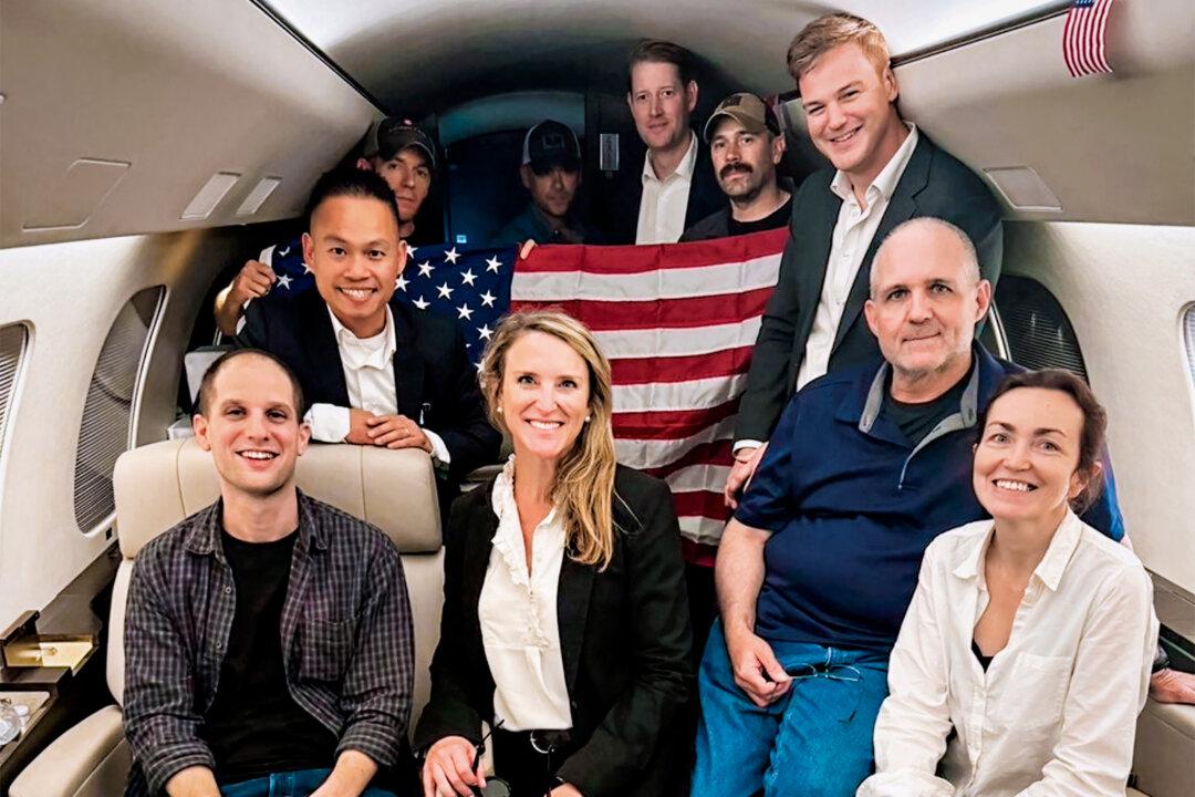 Americans Evan Gershkovich (L), Alsu Kurmasheva (R), Paul Whelan (2nd R), and others aboard a plane following their release from Russian captivity, on Aug. 1, 2024. (White House via AP)
