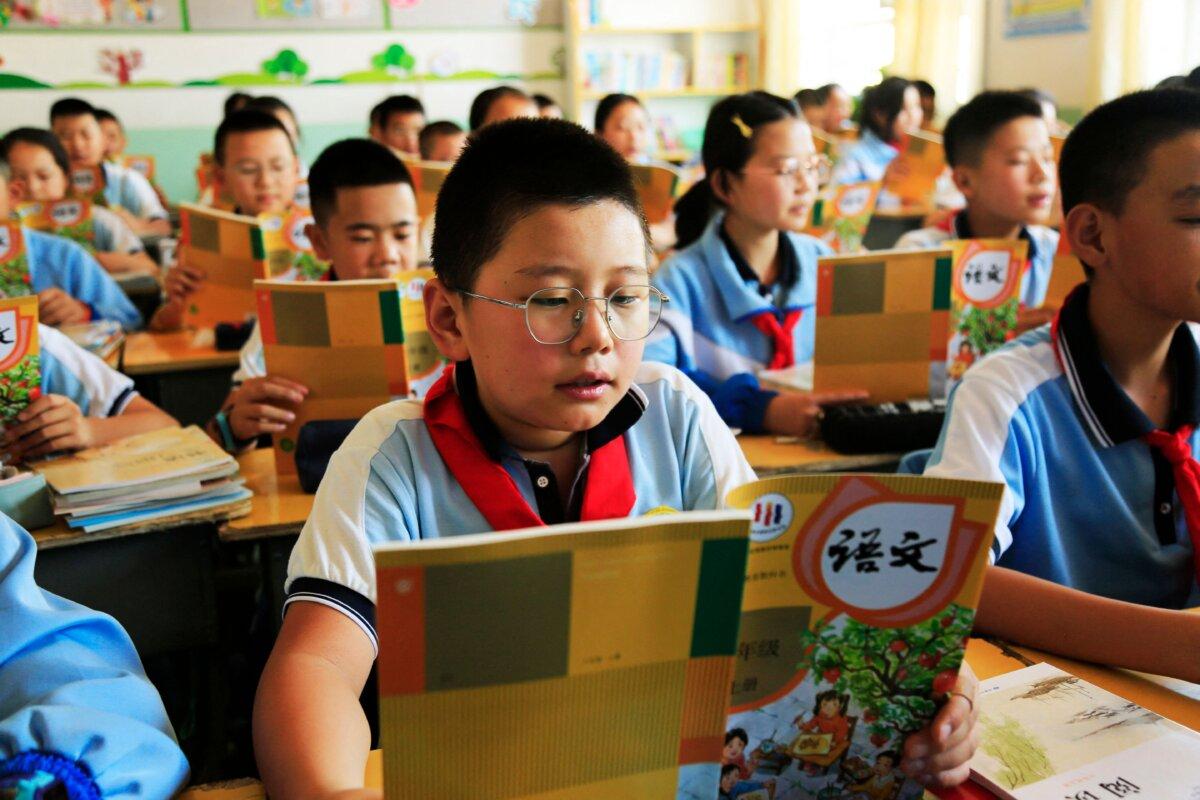 Students read from newly issued textbooks at a primary school in Zhangye City, in Gansu Province, China, on Aug. 28, 2023. (STR/AFP via Getty Images)