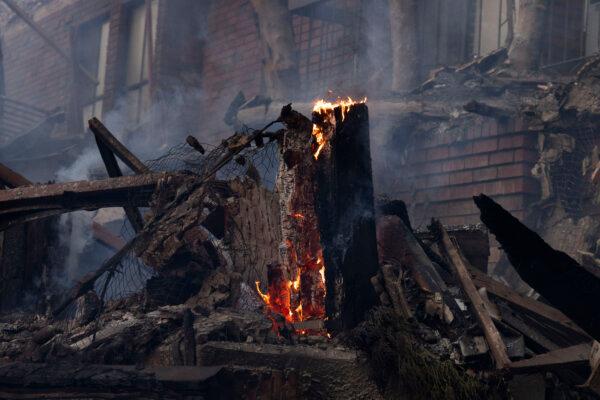 The remains of a tree stump smolders during the Palisades Fire near Los Angeles on Jan. 8, 2025. (John Fredricks/The Epoch Times)