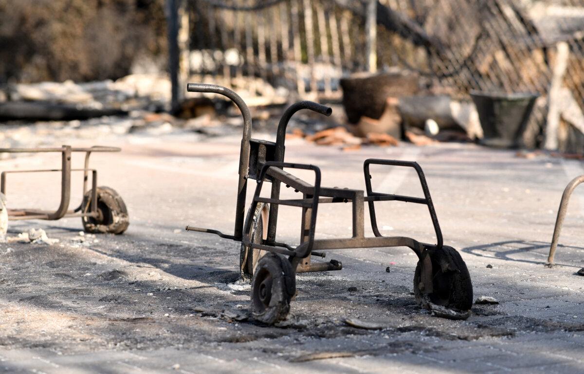 The metal skeleton of a tricycle is left among ashes of the Palisades campus of international private school Le Lycee Francais de Los Angeles after it was destroyed in the Palisades Fire in the neighborhood of Pacific Palisades in Los Angeles on Jan. 11, 2025. (Chris Delmas/AFP via Getty Images)