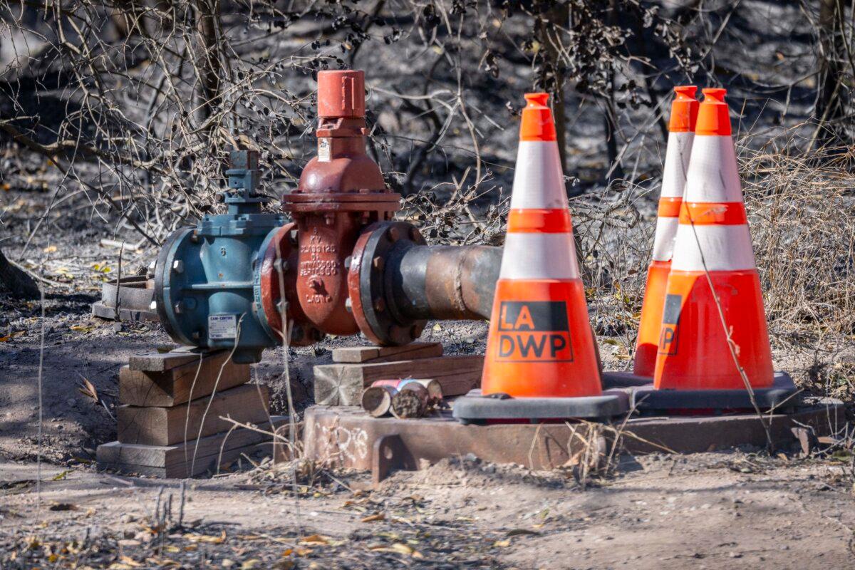 The perimeter of the Santa Ynez Reservoir sits in view of buildings destroyed by the Palisades fire near Los Angeles on Jan. 13, 2025. (John Fredricks/The Epoch Times)