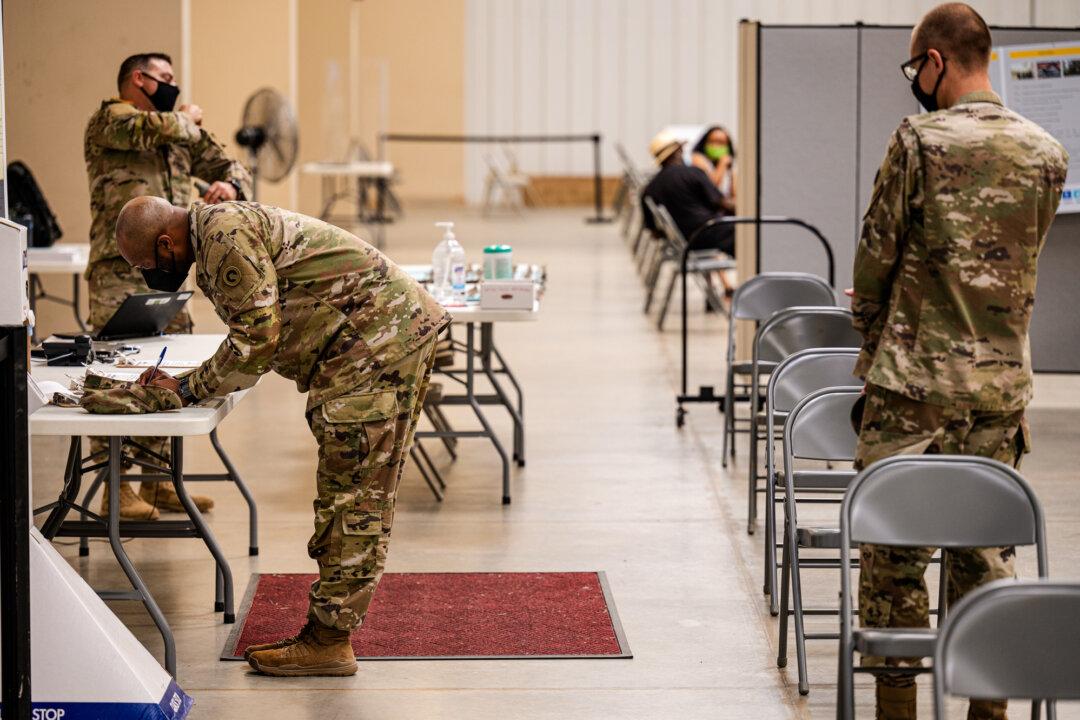 Soldiers file paperwork before receiving a COVID-19 vaccination by Army Preventative Medical Services in Fort Knox, Ky., on Sept. 9, 2021. The Pentagon, under President Joe Biden, mandated COVID-19 vaccinations for all military service members in early September 2021. (Jon Cherry/Getty Images)