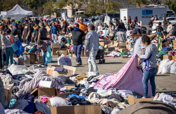 Fire victims sort through donated food and clothing piles at the Santa Anita racetrack near Los Angeles, Calif., on Jan. 14, 2025. (John Fredricks/The Epoch Times)