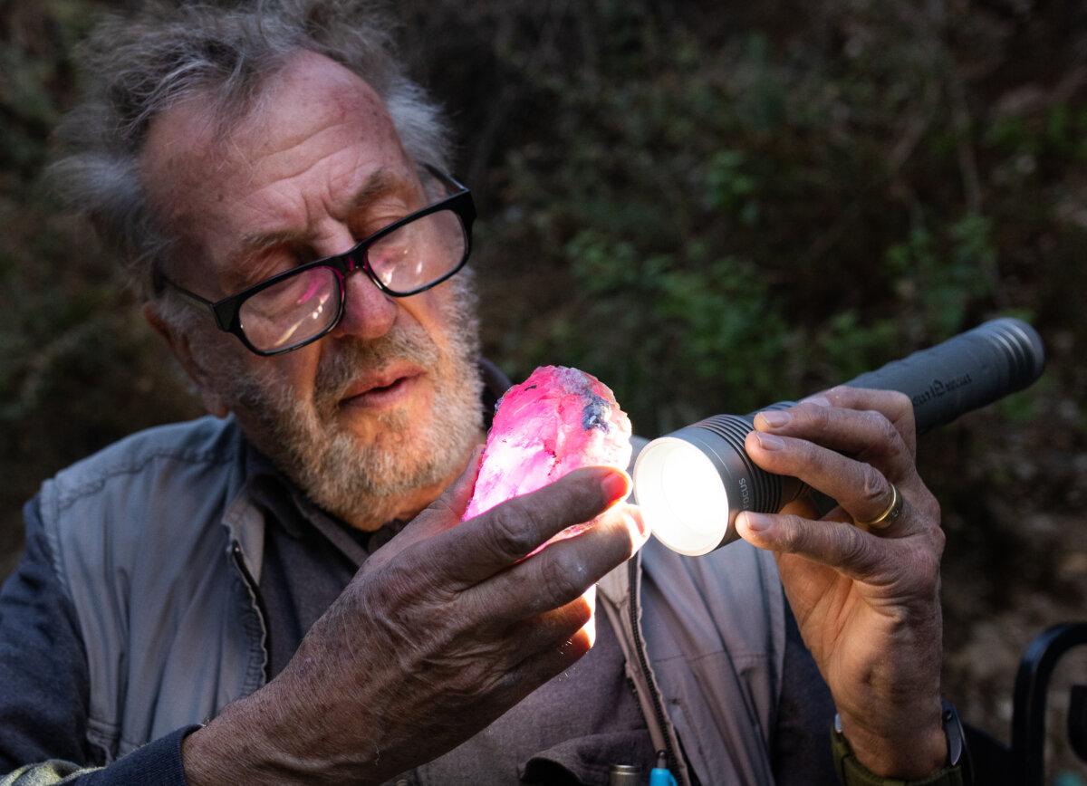 Miner and master gem cutter Blue Sheppard inspects a pink tourmaline specimen from the Stewart Mine near Pala, Calif., on Dec. 27, 2024. (John Fredricks/The Epoch Times)