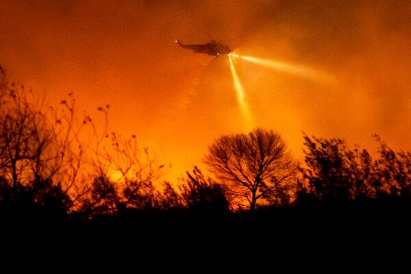 A helicopter drops water while fighting the Auto Fire in Ventura County, Calif., on Jan. 13, 2025. (Noah Berger/AP Photo)
