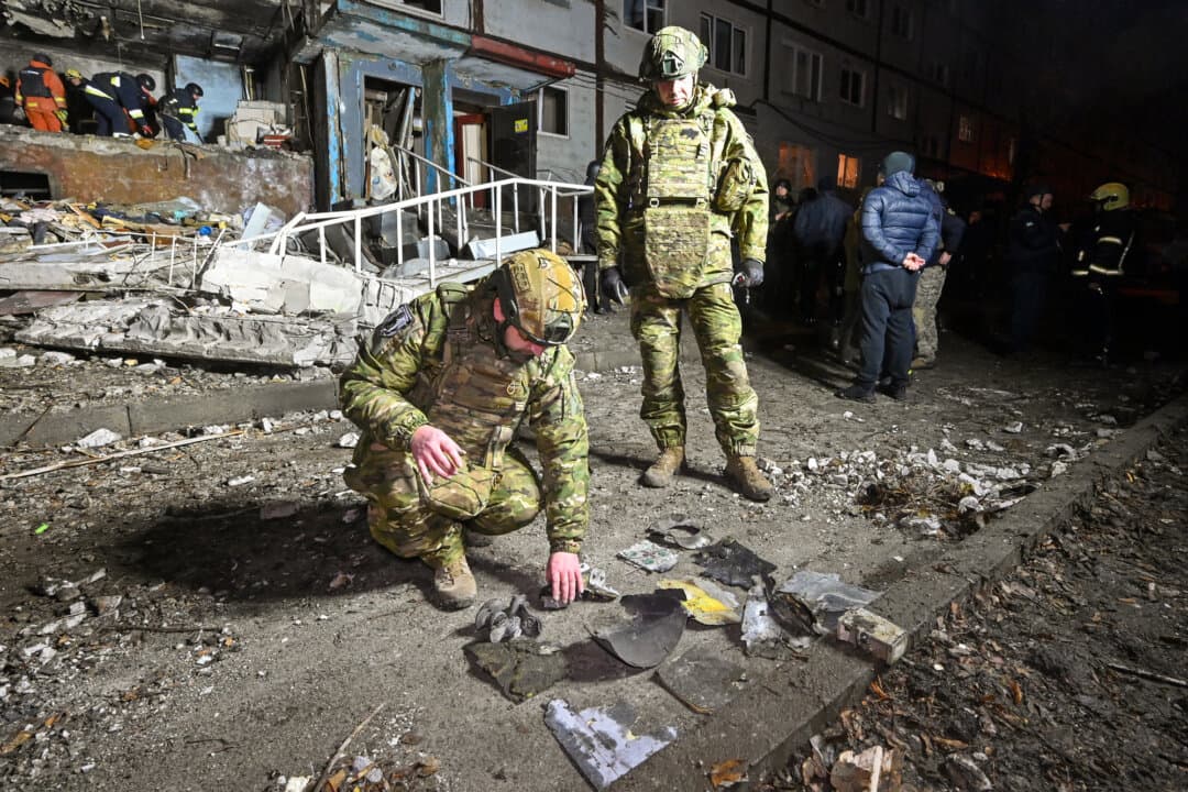 Ukrainian law enforcement officers inspect the remains of a drone in the courtyard of a damaged residential building following an attack in Kharkiv, Ukraine, on Dec. 20, 2024. (Sergey Bobok/AFP via Getty Images)