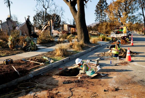 Utility workers restore a gas line near burnt homes in Pacific Palisades, Calif., on Jan. 17. (Fred Greaves /Reuters)