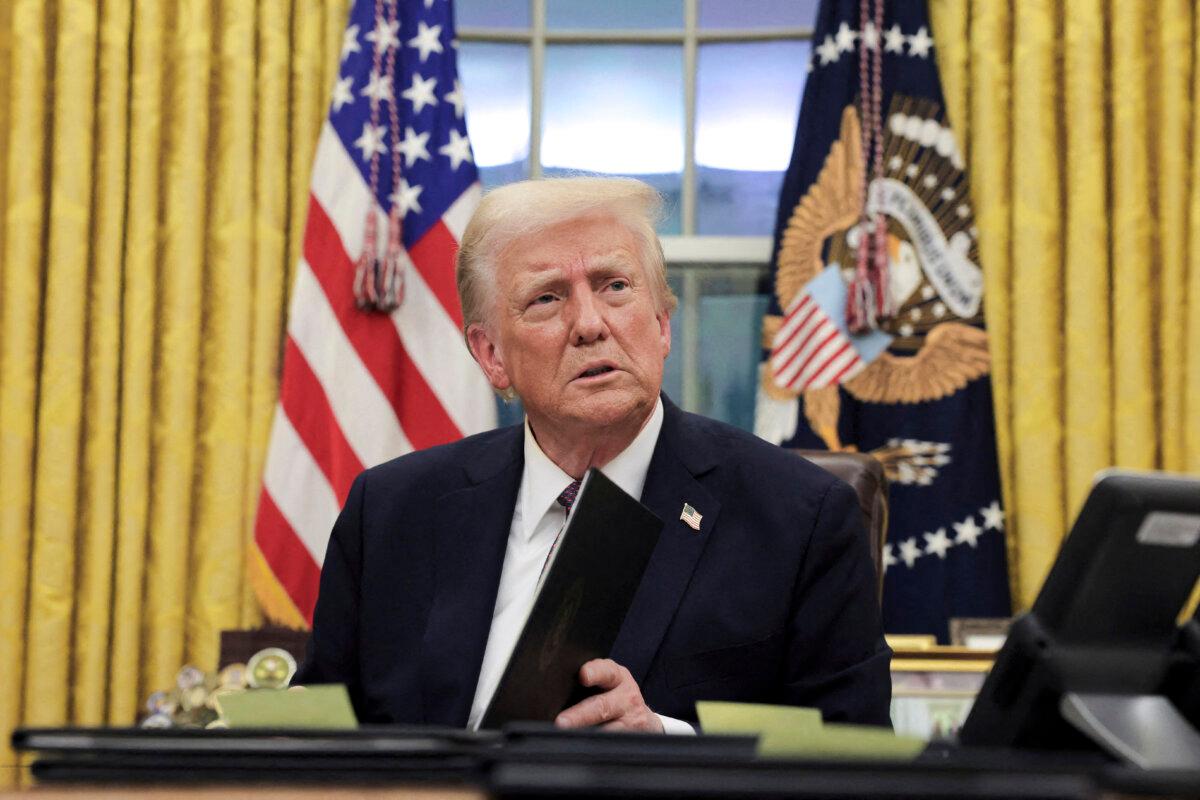 President Donald Trump signs documents as he issues executive orders and pardons for Jan. 6 defendants in the Oval Office on Jan. 20, 2025. (Carlos Barria/Reuters)