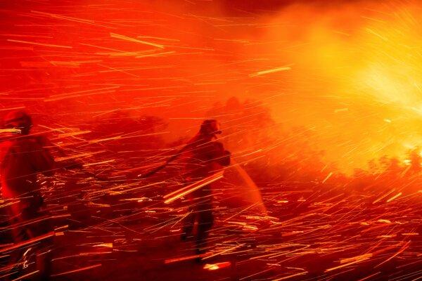 Firefighter Joshua Cari sprays water while battling the Lilac Fire near the Bonsall community of San Diego County, Calif., on Jan. 21, 2025. (Noah Berger/AP Photo)