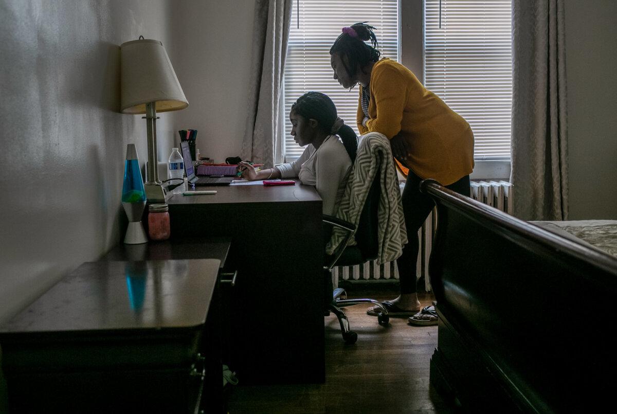 A student takes part in remote distance learning on a Chromebook with the help of her mother in Stamford, Conn., on Oct. 28, 2020. (John Moore/Getty Images)