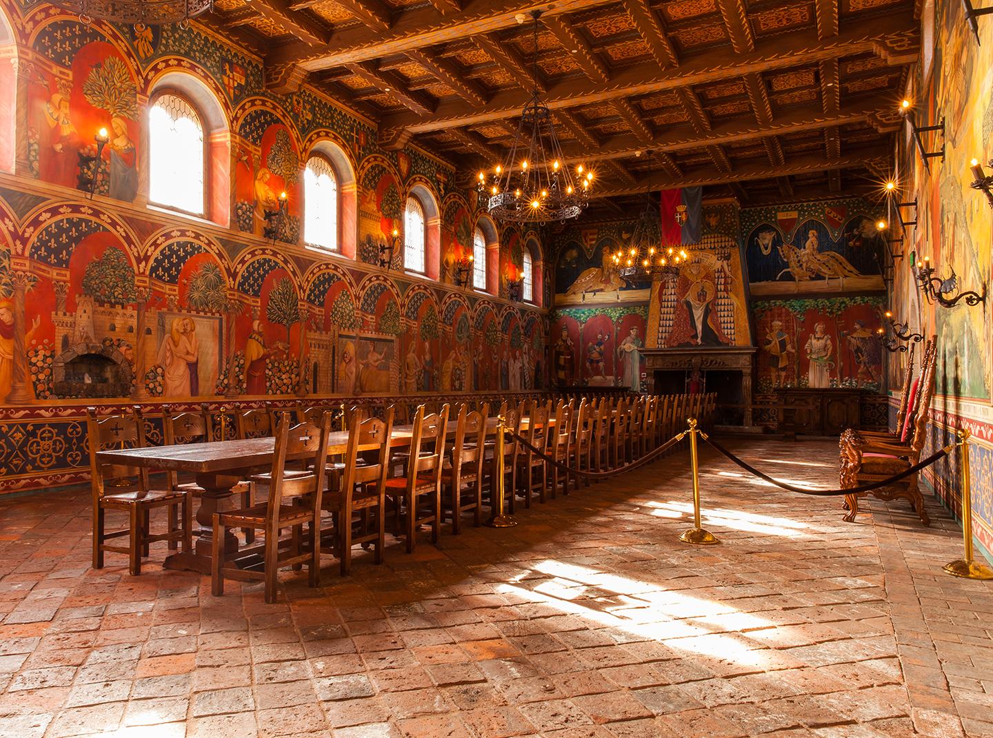 The Grand Hall is perhaps the most elaborate of all chambers—a term referring to castle rooms—at Castello di Amorosa. A 500-year-old fireplace from Umbria, Italy, was installed at one end. But most significant are the hand-painted Italian-style frescoes adorning the walls. The cross-beamed ceiling is stenciled. Besides all the sumptuous color in this arresting Grand Hall are the massive hand-forged iron candelabras suspended on iron rods. (Castello di Amorosa)