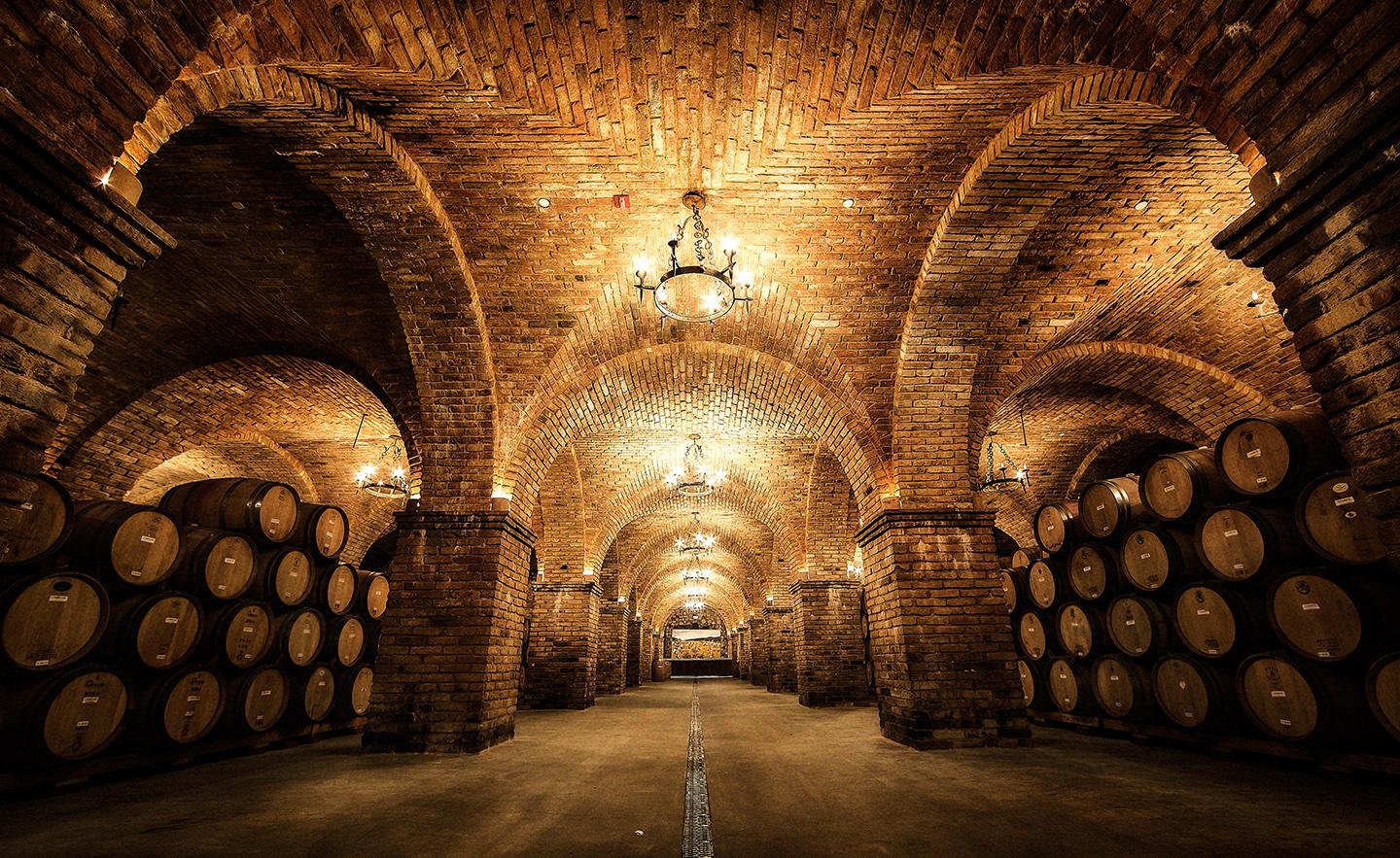 While the 12,000-square-foot barrel room is a functioning space to store wine barrels, it also showcases a ceiling of multiple cross (also referred to as groin) vaults made with distinct sandstone bricks. To achieve the elaborate ceiling display of 40 ribbed vaults, two barrel vaults, essentially extended arches, must intersect at right angles. The wide arches are perched on sandstone brick columns. (Castello di Amorosa)