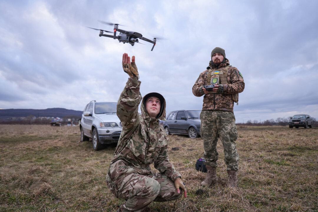 Participants practice flying a drone, in this case to locate colleagues who were hiding and pretending to be enemy snipers, during a combat training day hosted by a local paramilitary civil formation called TSEL, in Lviv region, Ukraine, on Feb. 22, 2023. (Sean Gallup/Getty Images)
