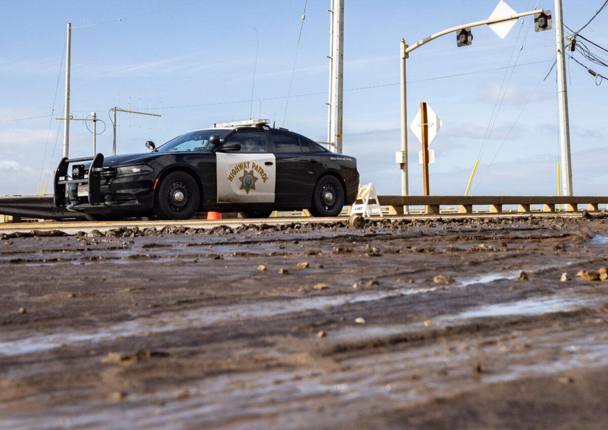 First responders and clean-up crews work to clear mud and debris flows left over from the Palisades Fire caused by heavy rains along Pacific Coast Highway near Los Angeles on Feb. 14, 2024. (John Fredricks/The Epoch Times)