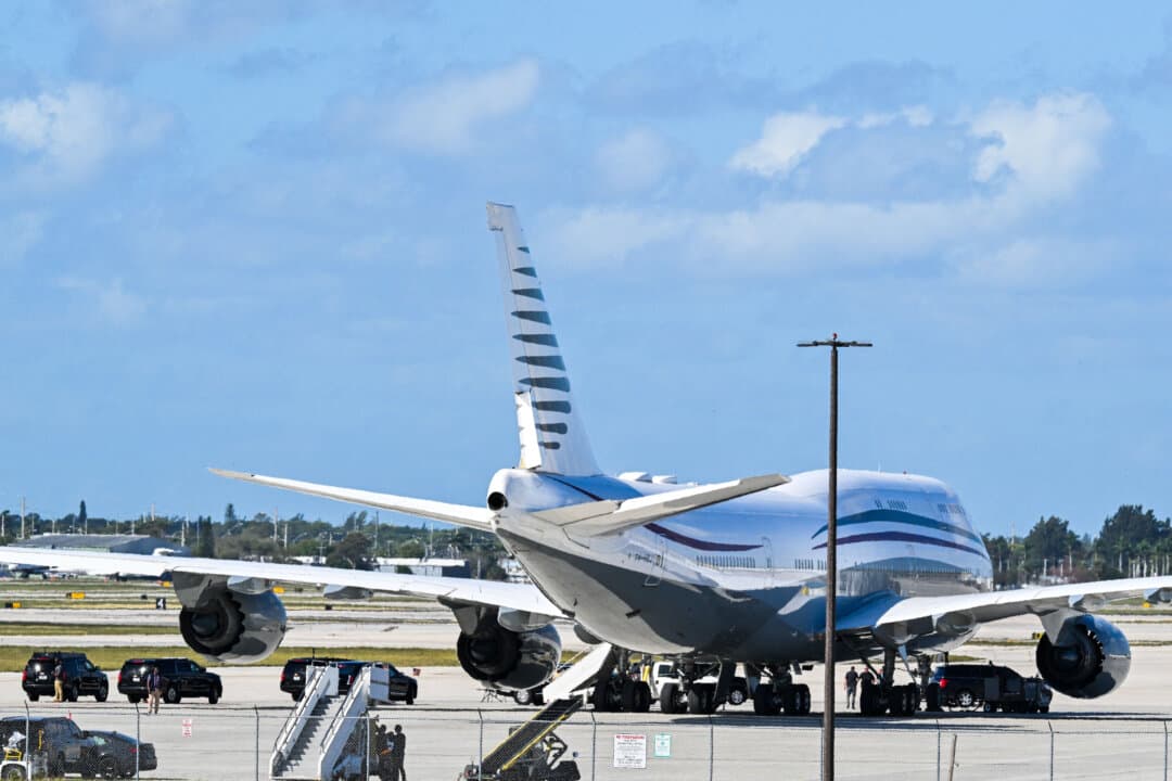 The motorcade of President Donald Trump is parked next to a 13-year-old Boeing 747 sitting on the tarmac at Palm Beach International Airport in West Palm Beach, Fla., on Feb. 15, 2025. Trump, who toured the plane, is reported to be frustrated by delays to two new presidential planes, which were meant to be delivered already but now may not be ready until 2028 or possibly later. (Roberto Schmidt/AFP via Getty Images)