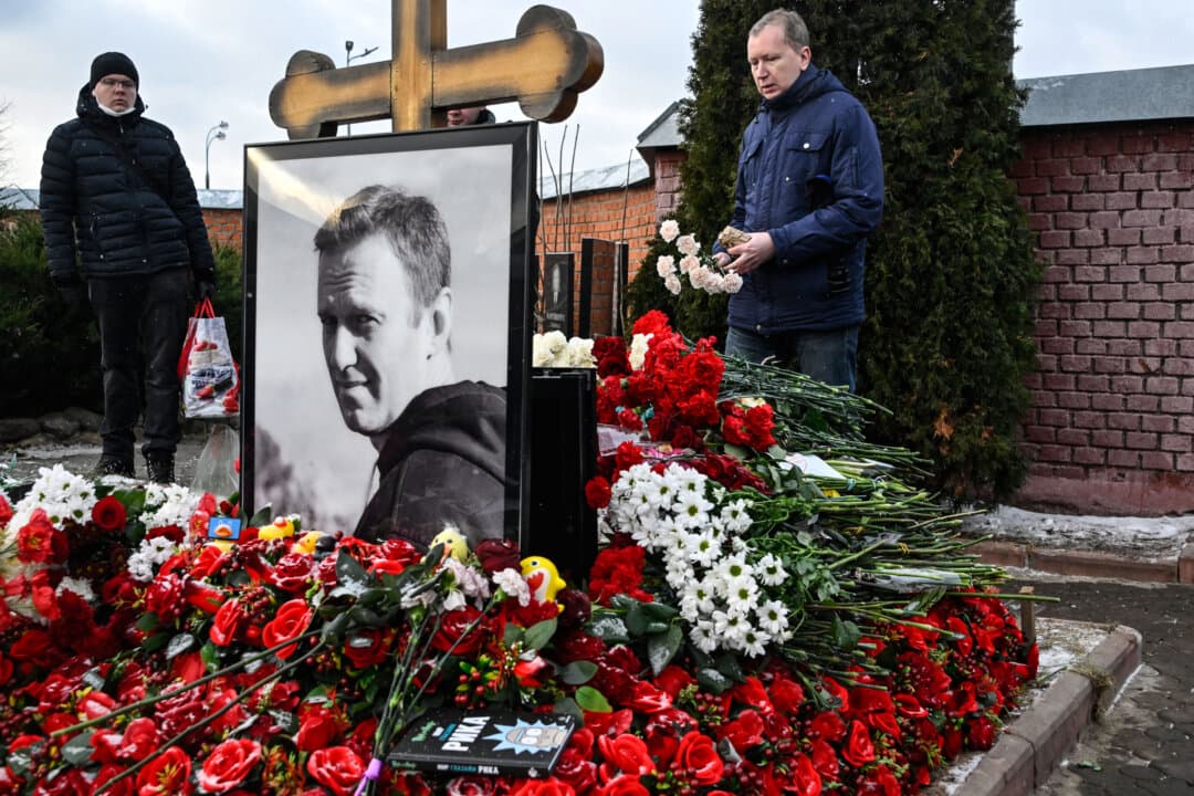 A man lays flowers at the grave of Russian opposition leader Alexei Navalny at the Borisovo cemetery in Moscow on Feb. 16, 2025, marking the first anniversary of his death. (Alexander Nemenov/AFP via Getty Images)