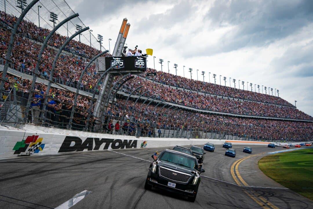 President Donald Trump rides in the presidential limousine during a pace lap ahead of the start of the Daytona 500 Nascar race at Daytona International Speedway in Daytona Beach, Fla., on Feb. 16, 2025. (Al Drago/POOL/AFP via Getty Images)